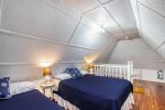 Attic loft with two full size beds. This room stays warm in the summer, but a window AC unit is provided.